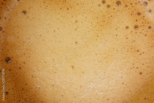 Aromatic coffee with foam from a capsule coffee machine in a cup, top view