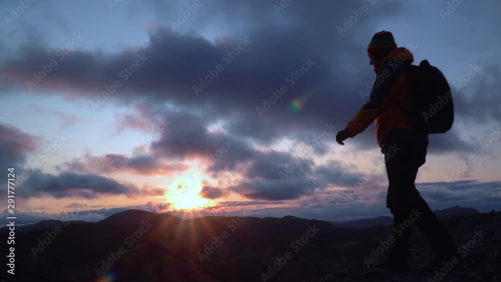 Silhouette of a man standing on top of the mountain in Iceland. Man raising arms victoriously after climbing the mountain. Slow motion Silhouette of a man standing on top of the mountain in Iceland. Man raising arms victoriously after climbing the mountain. Slow motion