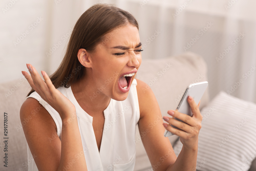 Angry Woman Shouting On Cellphone Sitting On Sofa At Home Angry Woman Shouting On Cellphone Sitting On Sofa At Home