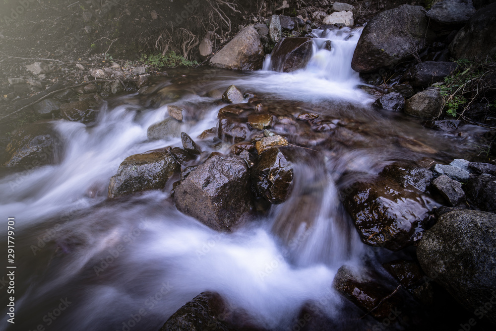 Agua cayendo desde la montaña entre rocas Agua cayendo desde la montaña entre rocas