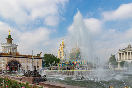 Kamennyy Tsvetok fountain and panoramic view of VDNH city park in sunny day with blue sky and clouds.