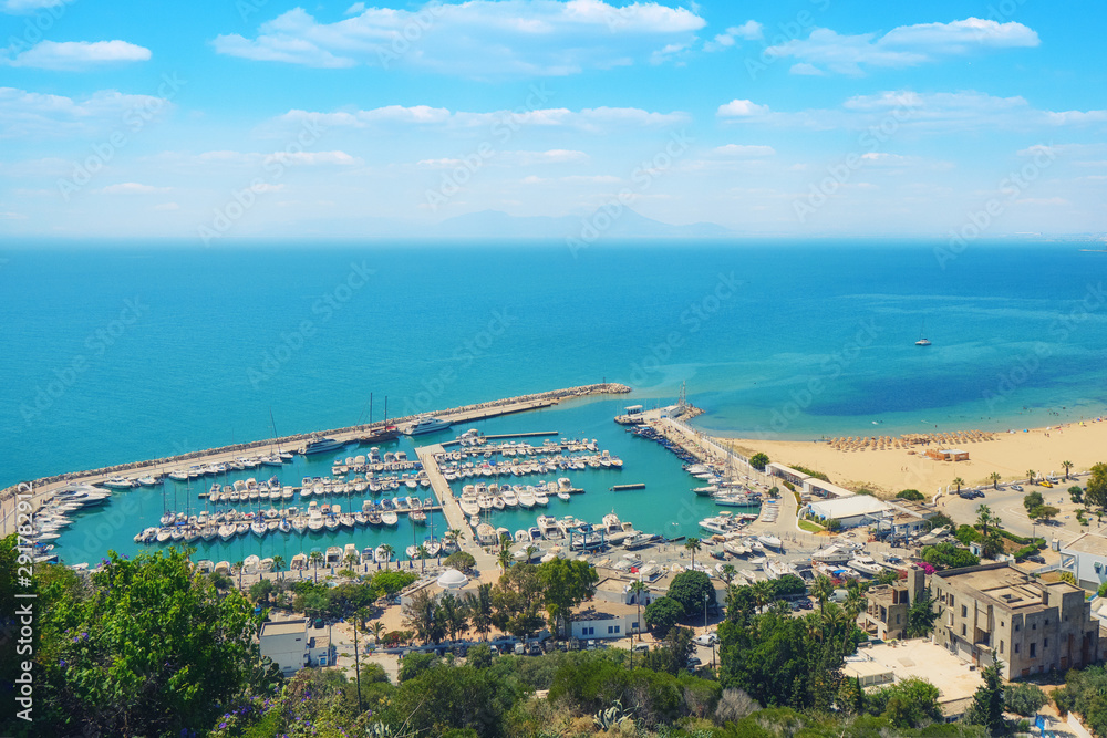 Top view of the sea, the port with ships and the road along the coast in Sidi Bou Said, Mediterranean, Tunisia. June, 2019