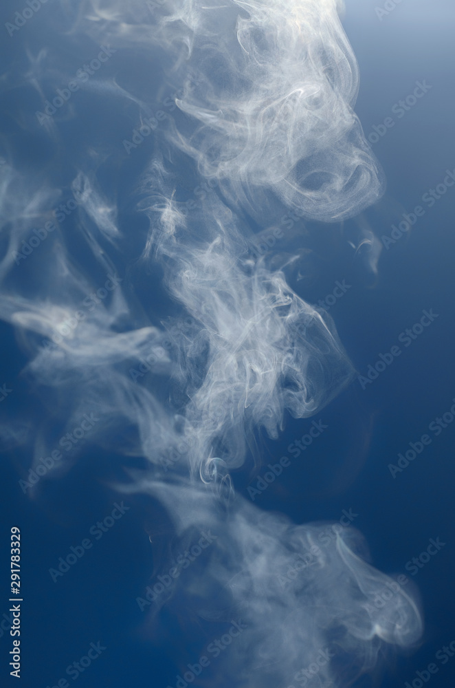 Thick white steam rises on a blue background Thick white steam rises on a blue background