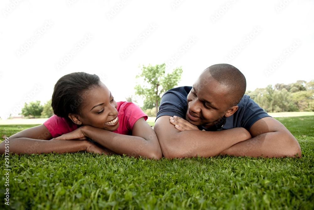 Closeup portrait of a young black couple, lying on the ground Closeup portrait of a young black couple, lying on the ground