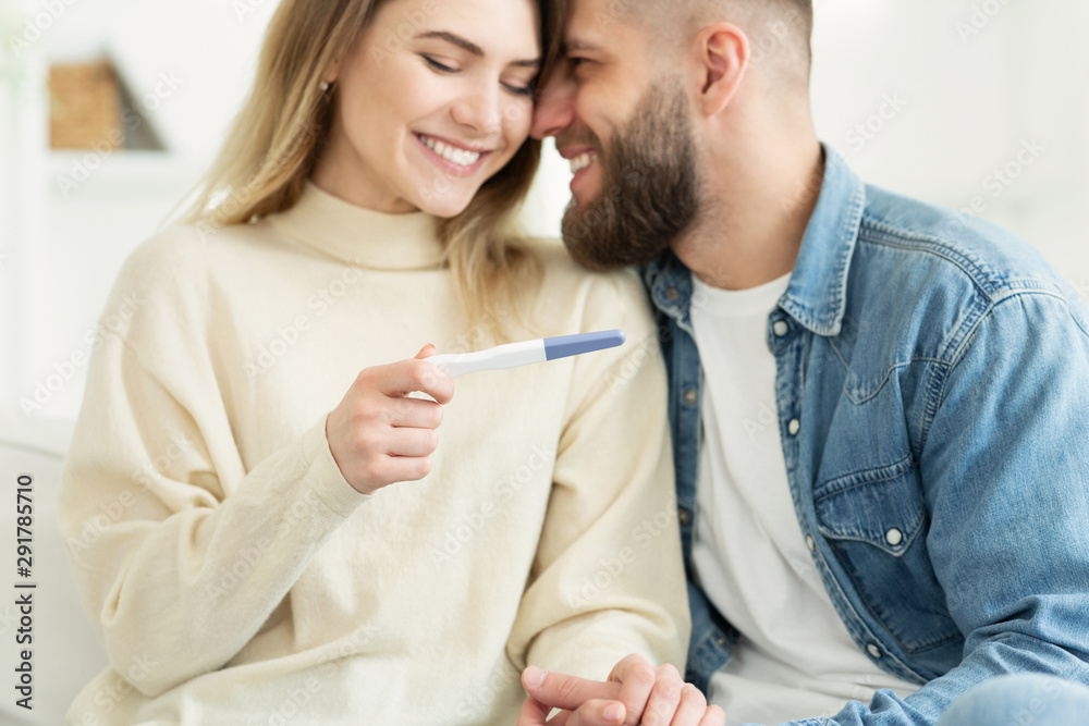 Happy couple checking pregnancy test, positive result Happy couple checking pregnancy test, positive result