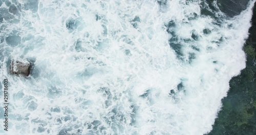Ocean waves crash on Australia shoreline, overhead aerial