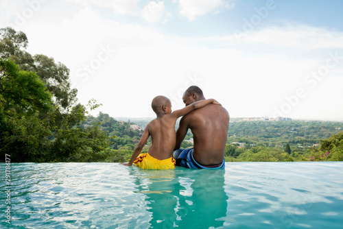 Father with son (8-9) playing in swimming pool