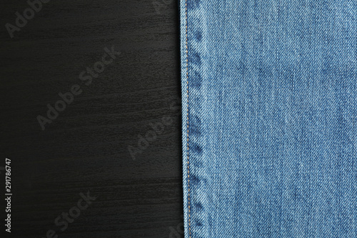 Classic jeans on black background, space for text