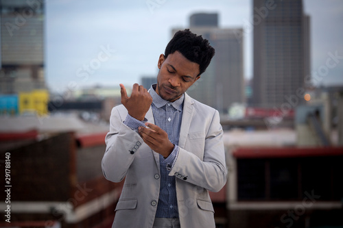 Business man buttoning up shirt cuff