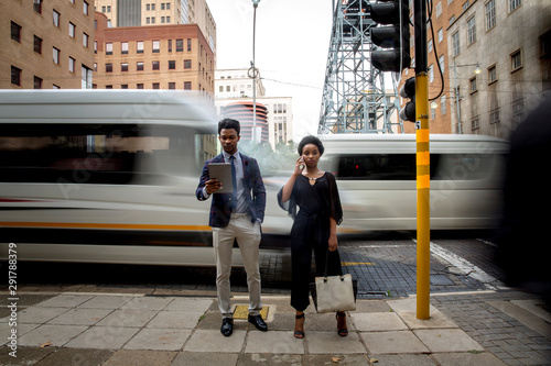 Businessman and businesswoman standing beside traffic light photo