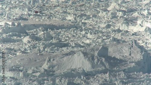 Helicopter flies over glacial landscape, wide