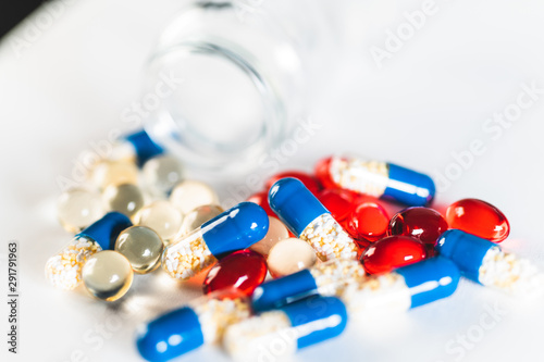 Medicine red and blue pills or capsules on white background with copy space. Drug prescription for treatment medication. Pharmaceutical medicament, cure in container for health. Antibiotic
