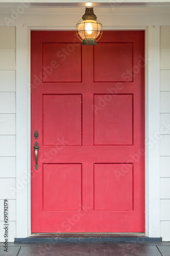 extra large wide red painted front door of a house home with a vintage light