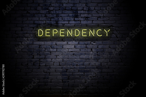 Highlighted brick wall with neon inscription dependency