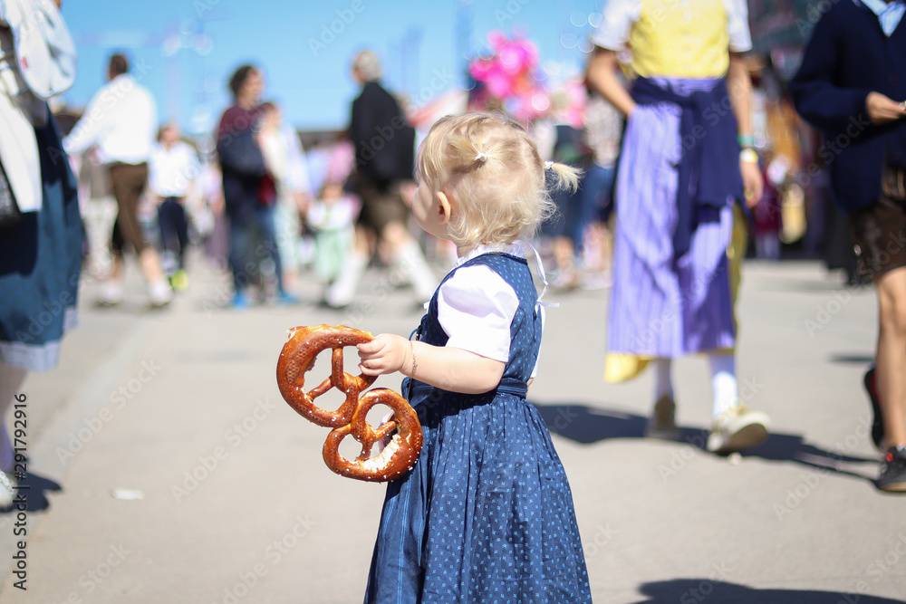 Obraz premium Kind auf dem Oktoberfest mit Brezel in der Hand