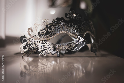 A portrait of a venetian mask emitting mystery and excitement. The mask is ready to be used for carnaval, a masked ball or halloween.