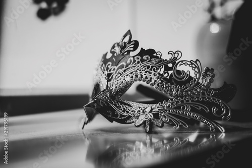 A black and white portrait of a mysterious venetian mask lit by a window. A great way to hide your identity on a masked ball, carnival or halloween party.