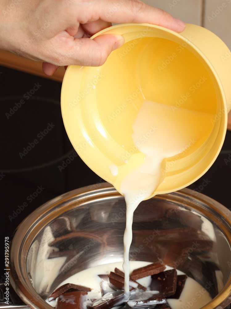 A chef pouring milk into a chocolate. Making Chocolate Cream. Series. A chef pouring milk into a chocolate. Making Chocolate Cream. Series.