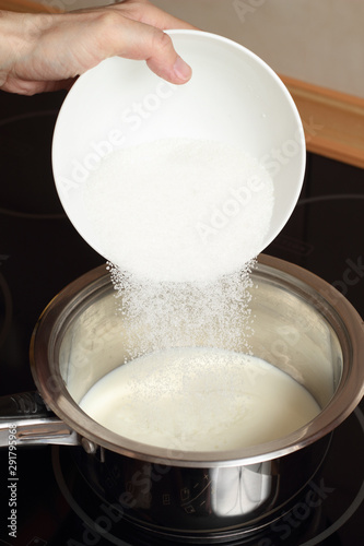 A chef pouring sugar into a milk. Making Chocolate Cream. Series.