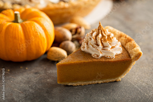 Traditional pumpkin pie topped with whipped cream