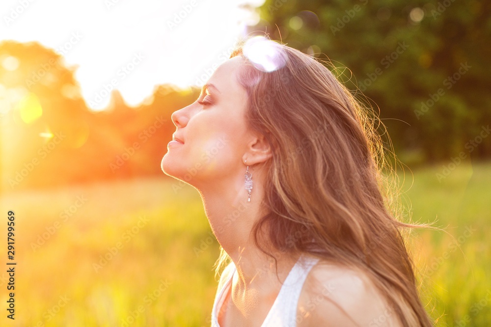 Young woman on field under sunset light Young woman on field under sunset light