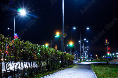 a deserted night road illuminated by led lights after rain in a provincial town