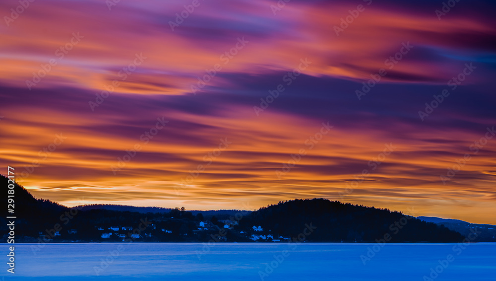 Różowo czerwony zachód słońca nad Drøbak w Norwegii 