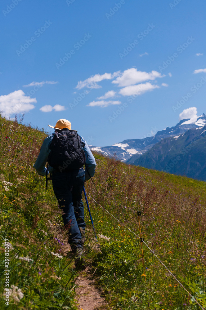 Man climbing a mountain with backpack and yellow hat