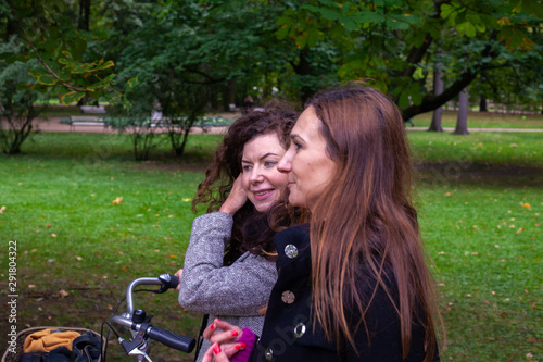 2 girls discussin while walking in Lazenki park in Warsaw photo