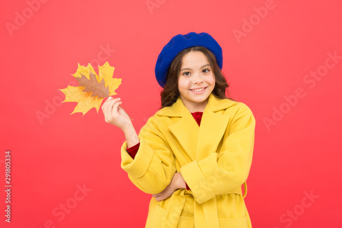Good mood at any weather. school time. childhood happiness. fall season. fallen leaves bunch. happy small girl with maple leaf. autumn kid fashion. parisian girl child in french beret and yellow coat