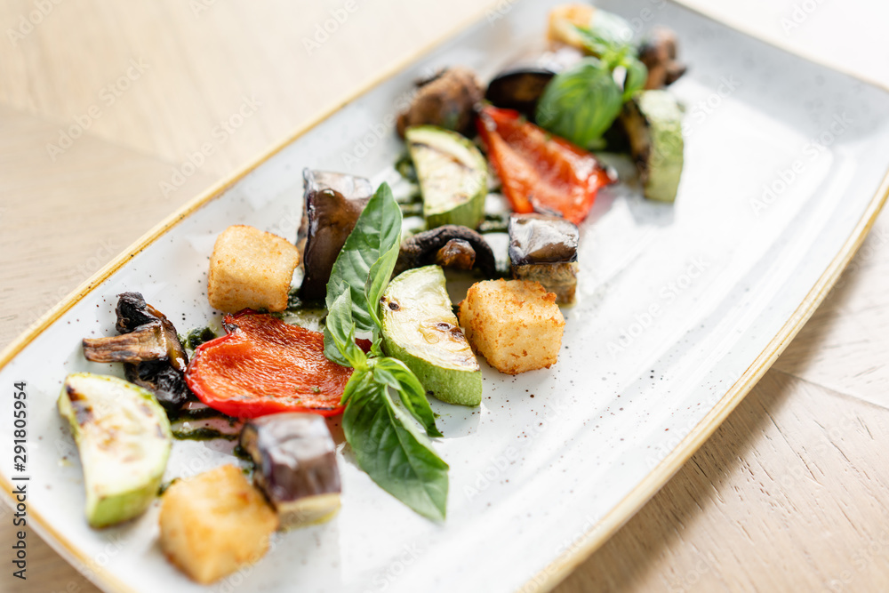 Grilled vegetables with feta cheese. Serving on a plate on a table. Barbecue restaurant menu, a series of photos of different dishes Grilled vegetables with feta cheese. Serving on a plate on a table. Barbecue restaurant menu, a series of photos of different dishes