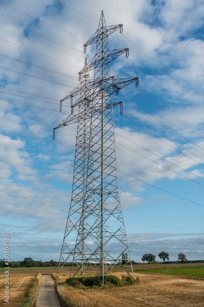 Strommasten unter dunklem Wolkenhimmel