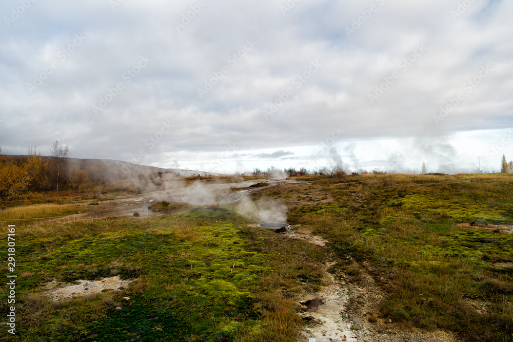 Geyser natural miracle. Steam of hot mineral source in Iceland. Iceland famous for geysers. Iceland geyser park. Landscape meadow with clouds of steam. Geysir hot spring area. Highly active geyser