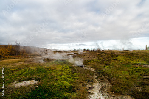 Geyser natural miracle. Steam of hot mineral source in Iceland. Iceland famous for geysers. Iceland geyser park. Landscape meadow with clouds of steam. Geysir hot spring area. Highly active geyser
