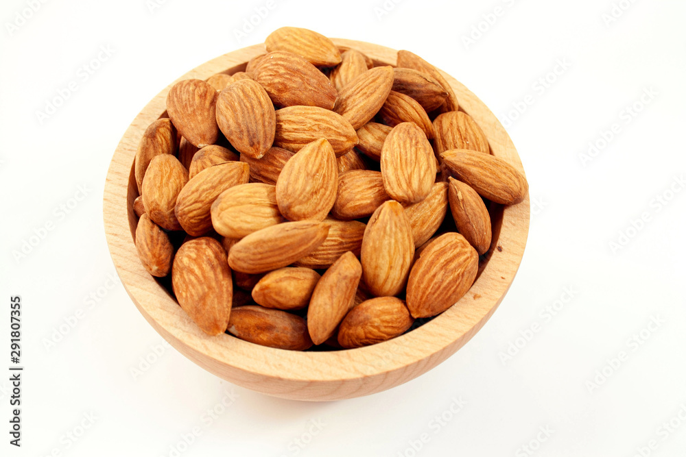 Almonds in a wood bowl on white background Almonds in a wood bowl on white background