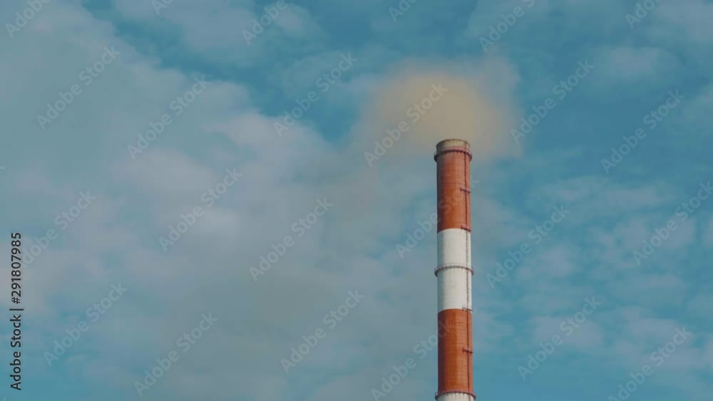 Steam, smoke from pipes at a thermal power station. Russia Novosibirsk. Close-up of a red pipe at a plant producing harmful chemicals. Smoke pollutes the atmosphere. Steam, smoke from pipes at a thermal power station. Russia Novosibirsk. Close-up of a red pipe at a plant producing harmful chemicals. Smoke pollutes the atmosphere.