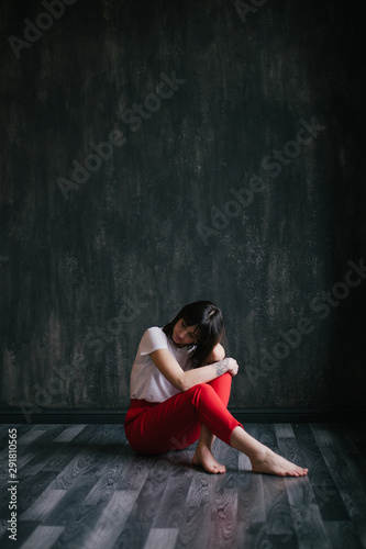 Portrait of young depressed woman on black background. © polinaloves