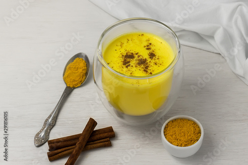 Traditional Indian drink. Golden latte, turmeric milk with spice on a white wooden background