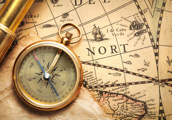 antique compass and spyglass on ancient map by H. Hondius dated 1630AD