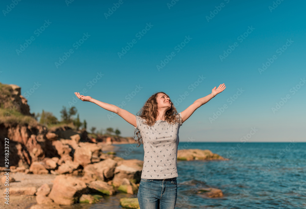 Backview woman traveler posing with raising arms relaxing on viewpoint at islands. Sexy tan perfect fit body woman. Portrait of glamour lady enjoying her vacation. Beautiful seascape, travel Backview woman traveler posing with raising arms relaxing on viewpoint at islands. Sexy tan perfect fit body woman. Portrait of glamour lady enjoying her vacation. Beautiful seascape, travel