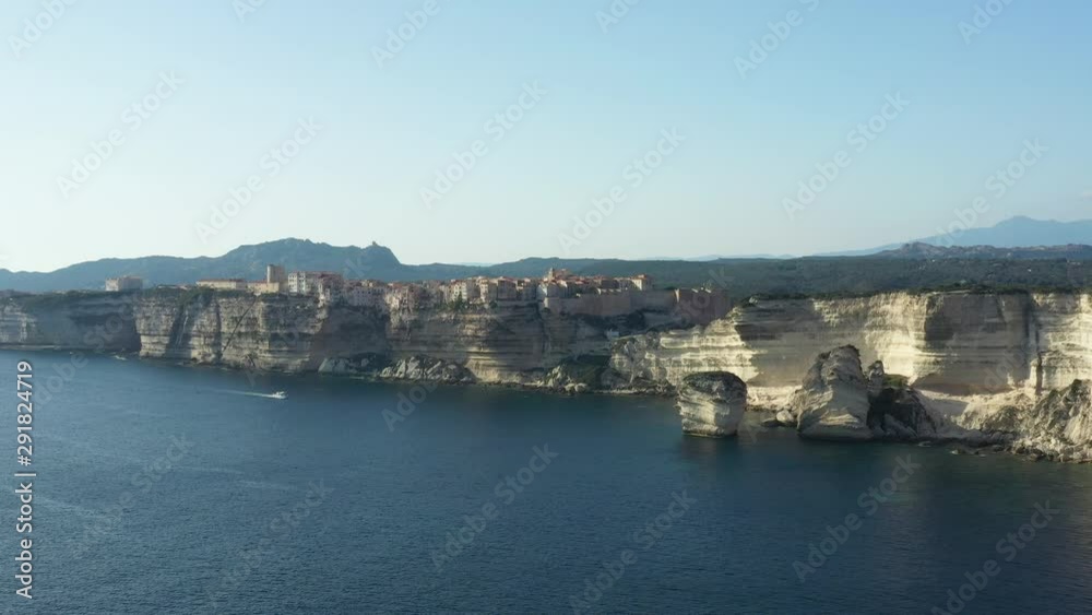 View from above, stunning sunset that illuminates the beautiful village of Bonifacio built on a limestone cliff. Bonifacio is a commune at the southern tip of the island of Corsica, France. View from above, stunning sunset that illuminates the beautiful village of Bonifacio built on a limestone cliff. Bonifacio is a commune at the southern tip of the island of Corsica, France.