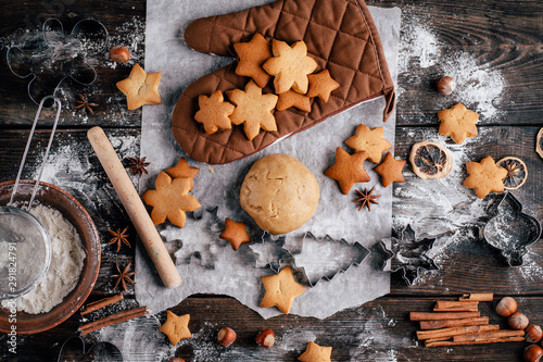 Fényképezés Freshly baked appetizing homemade gingerbread cookies, raw dough, baking utensils and food decorations