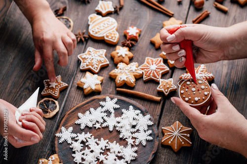 Christmas and New Year celebration traditions, festive sweets, family culinary. Traditional gingerbread. Friends decorating freshly baked cookies with icing and mastic