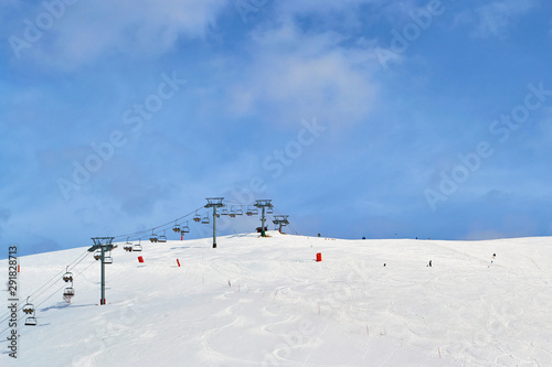 Ski chair lift in France, with blue sky and few clouds - copy space above.