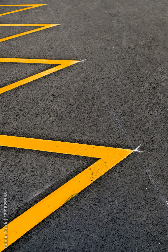 Parking lot marked in yellow reflective paint, an abstract detail.