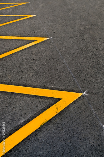 Parking lot marked in yellow reflective paint, an abstract detail. © Daguimagery