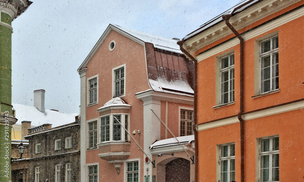 Obraz premium Snowing. People walk in Old city. Urban landscape in winter. Nice photo of an ancient European town. North Europe. Architecture of Tallinn, Estonia – November 5, 2016