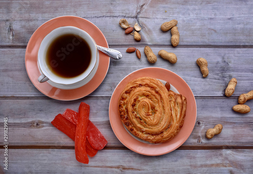 Rustic. Sweet bun. Cup of tea. Peanuts. Wood background. Nuts. Fall. Autumnal still life. Top view.