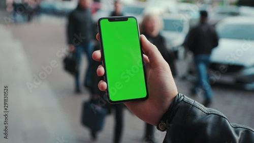 Wallpaper Mural NEW YORK - April 5, 2018: Young man hands holding a smartphone with vertical green screen background car people city touchscreen wireless business evening cellphone communication device digital Torontodigital.ca