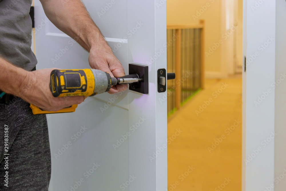 Handyman installing the door lock in the room with screwdriver, Close-up of new a house
